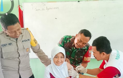 Bersama Bhabinkamtibmas Polsek Sukosewu, Babinsa Koramil Sukosewu dampingi Nakes berikan Layanan Imunisasi